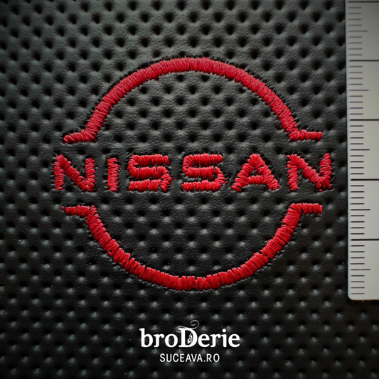 Logo NISSAN brodat pe piele cu ata rosie